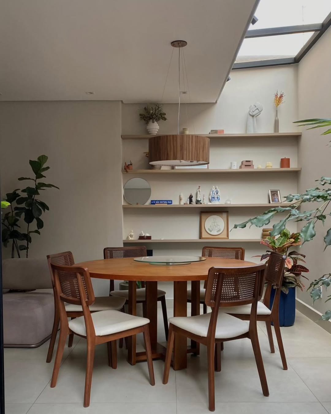 Sala de jantar com mesa redonda e estante de nichos
